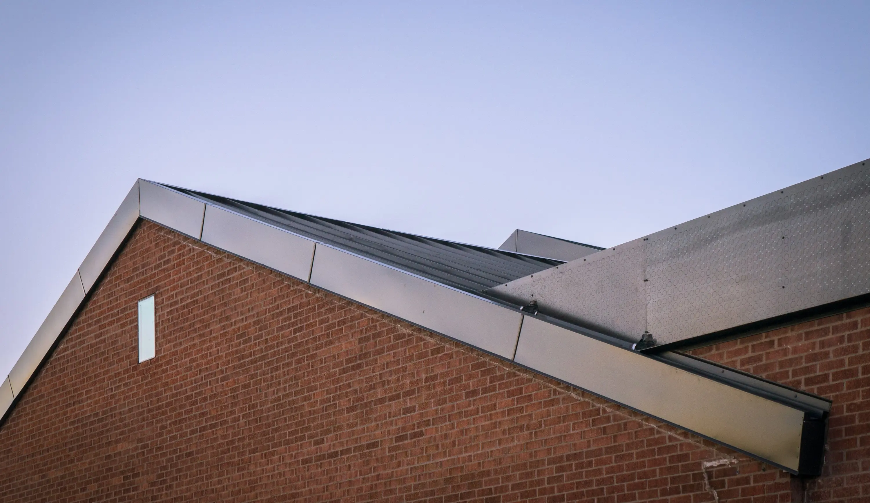 Brick gable and metal roof edge at Meetinghouse 3080