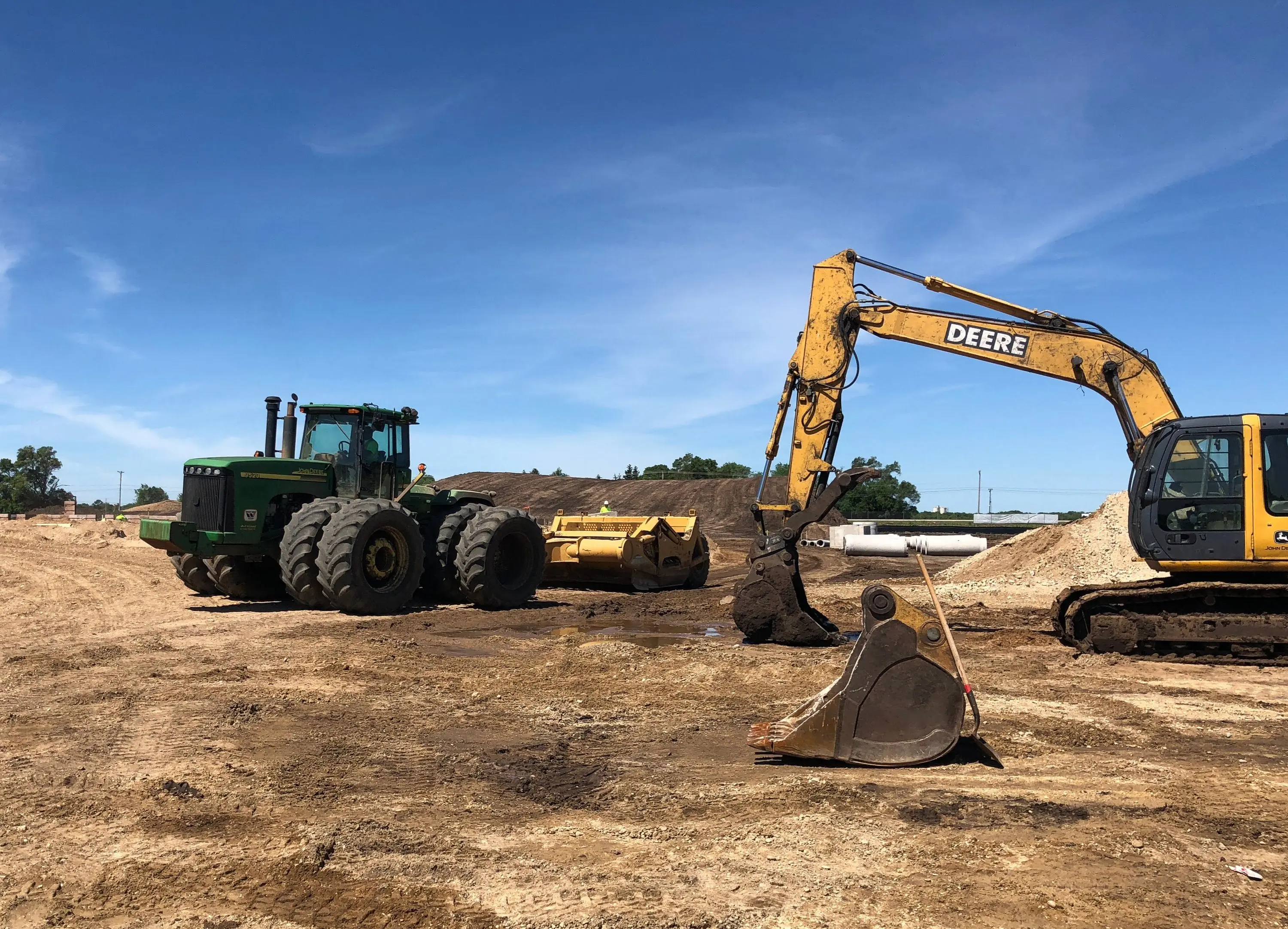 Excavator and tractor clearing a construction site at Camping World Roscoe